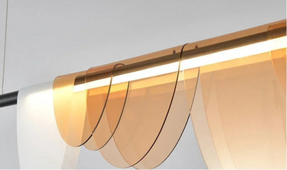 Close-up detail of the amber acrylic petal pendant light showing the layered semicircular acrylic shades and warm LED light bar — LivDecor