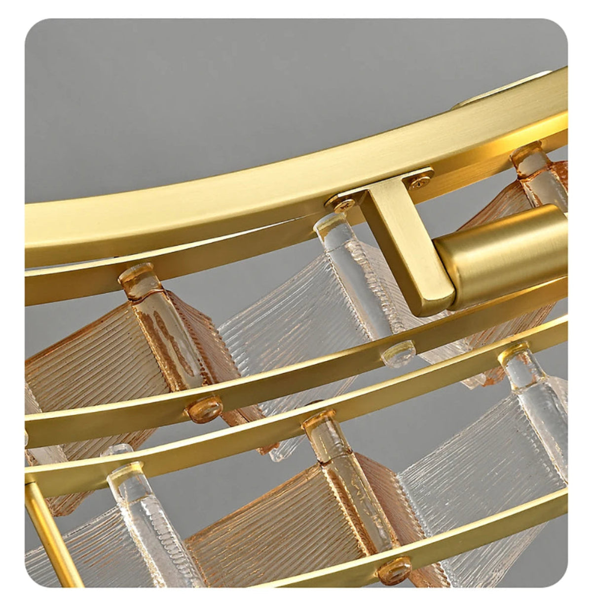 Close-up detail of amber and clear ribbed glass panels secured in brushed gold curved iron frame of the round chandelier showing build quality and glass texture — LivDecor

