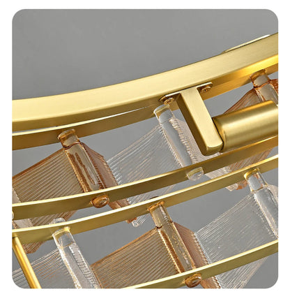Close-up detail of amber and clear ribbed glass panels secured in brushed gold curved iron frame of the round chandelier showing build quality and glass texture — LivDecor
