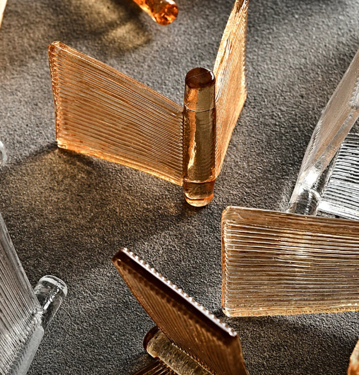 Extreme close-up of amber and clear ribbed glass panels showing fine linear texture and warm honey tones of the glass used in LivDecor chandeliers and wall sconces — LivDecor