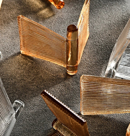 Extreme close-up of amber and clear ribbed glass panels showing fine linear texture and warm honey tones of the glass used in LivDecor chandeliers and wall sconces — LivDecor