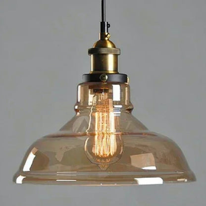 Amber glass industrial dome pendant light with brass Edison fitting and lit filament bulb glowing warmly against a grey background — LivDecor
