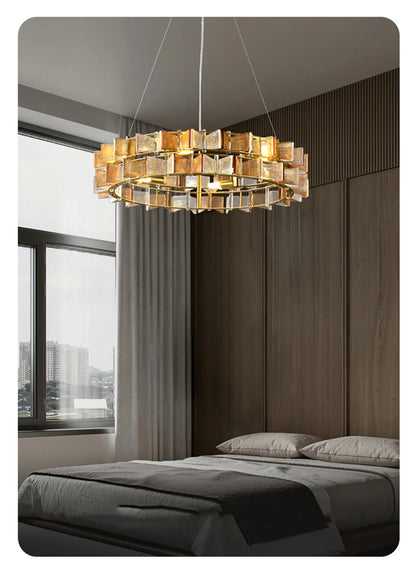 Amber ribbed glass iron round chandelier with gold frame hanging above a modern bed in a contemporary bedroom with floor-to-ceiling windows and city view — LivDecor