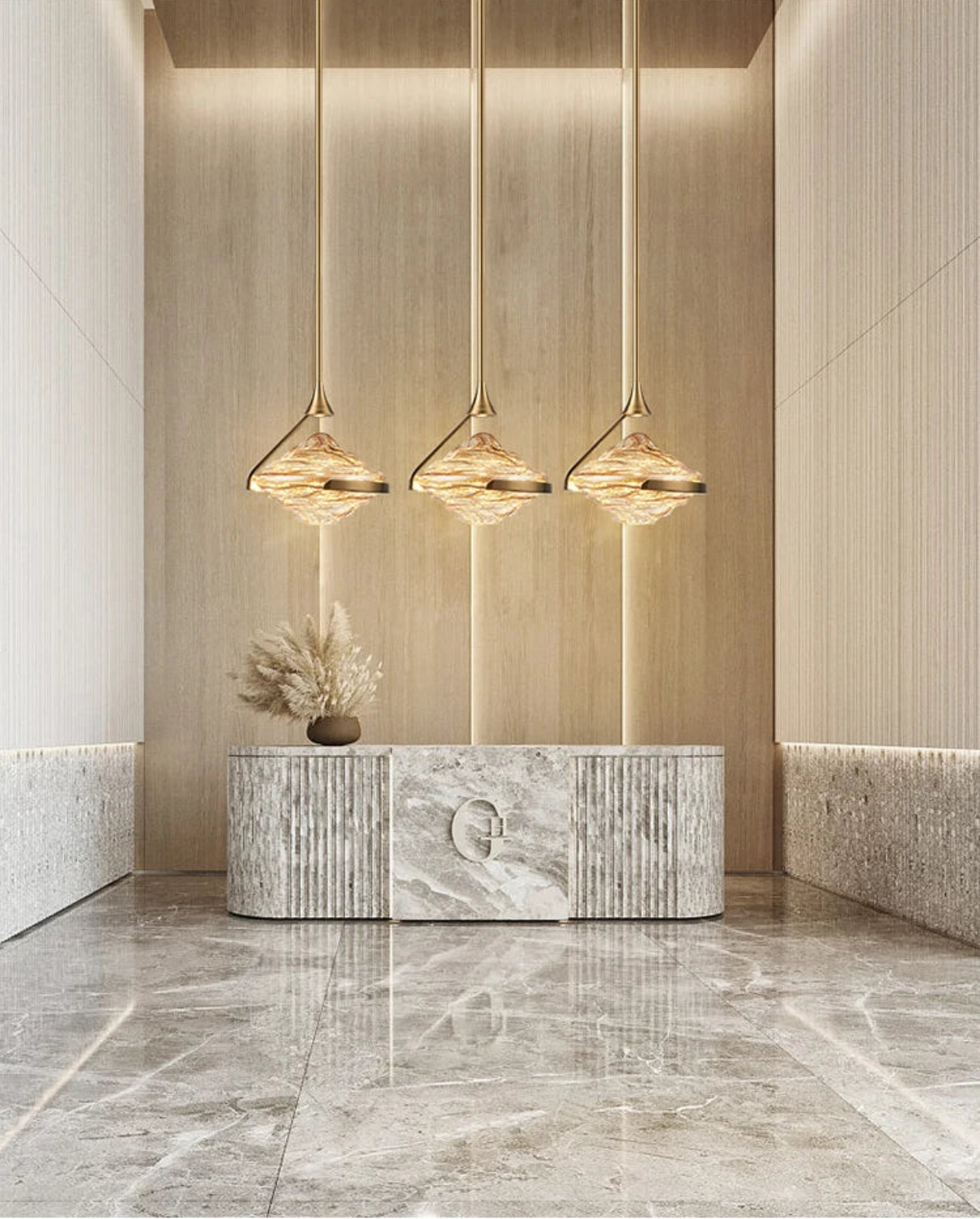 Three amber wave glass geometric pendant lights on gold stems hanging above a marble reception desk with pampas grass decor in a luxury hotel lobby with warm wood paneling and marble floors — LivDecor