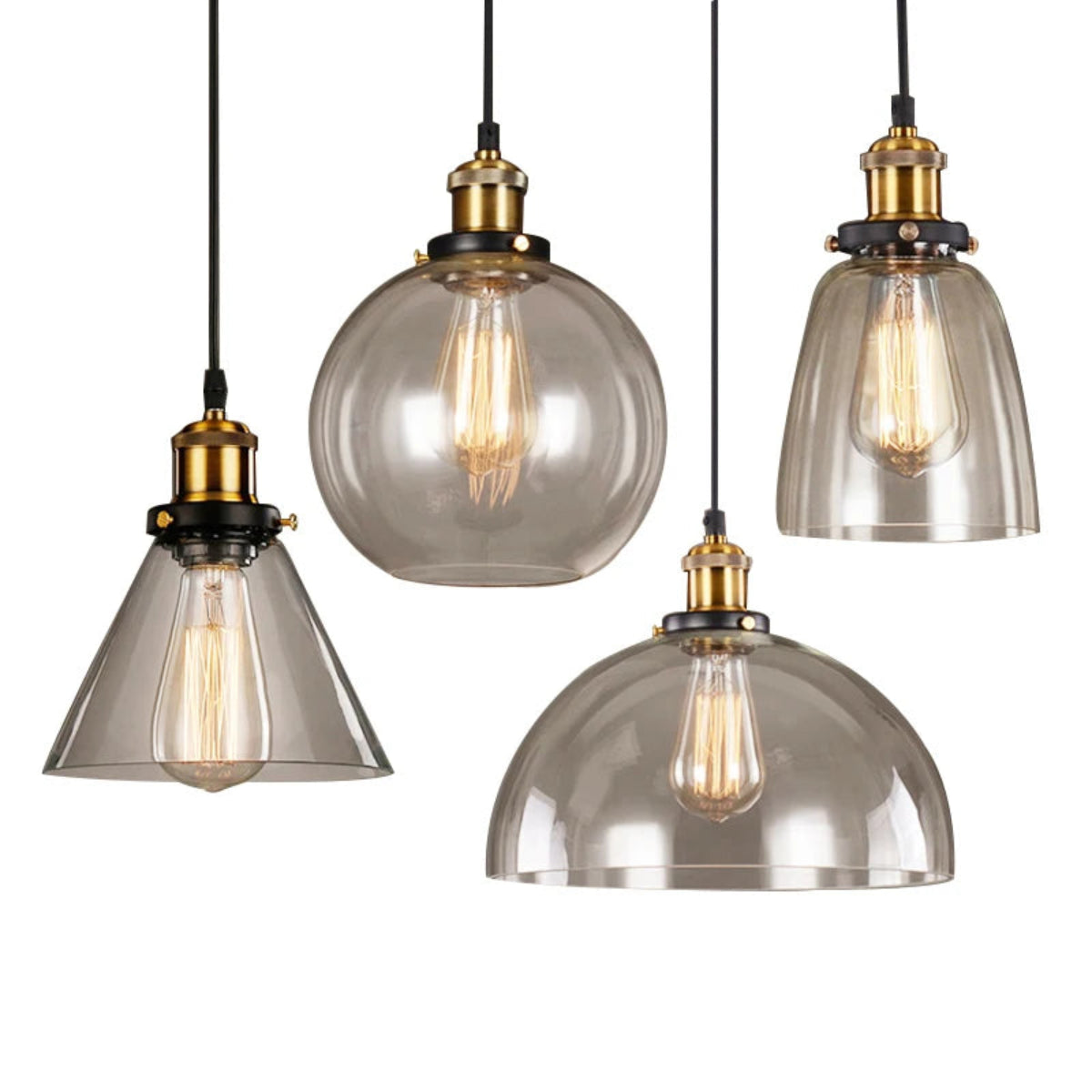 Four smoky amber glass pendant lights — cone, globe, bell, and dome styles — with antique brass sockets and Edison filament bulbs on black cords against a white background — LivDecor