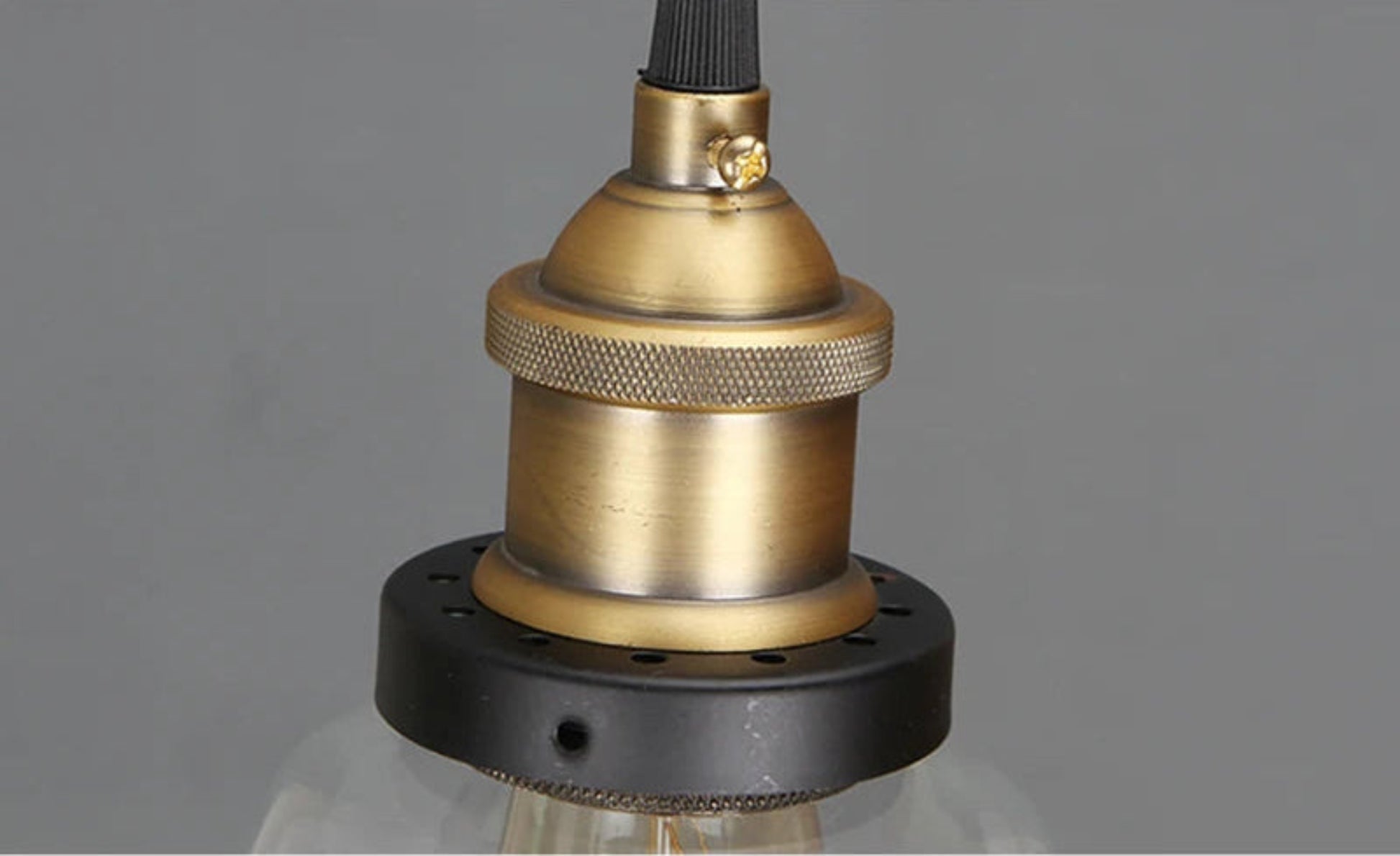 Close-up detail of antique brass knurled socket and matte black ring hardware on a pendant light — LivDecor