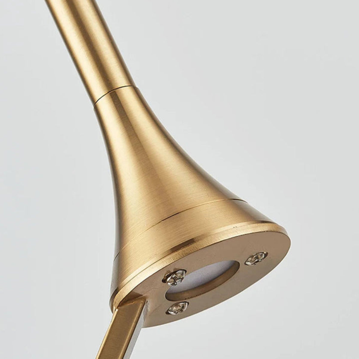 Close-up detail of the brushed gold stem and integrated LED light module on the wave glass geometric pendant light — LivDecor