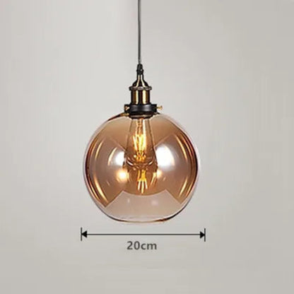 Single amber glass globe pendant light with antique brass socket and Edison filament bulb on black cord, 20cm diameter — LivDecor