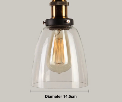 Close-up of a single clear glass cone pendant light with antique brass and black socket and glowing Edison filament bulb, 14.5cm diameter — LivDecor
