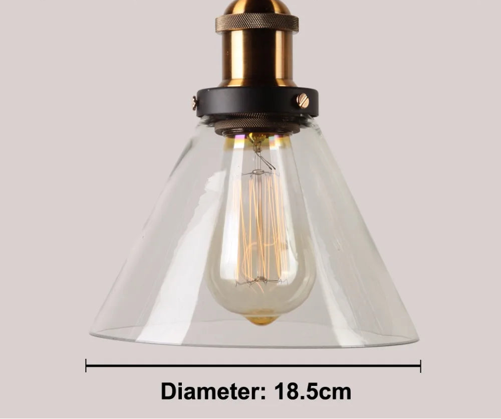 Close-up of a single clear glass cone pendant light with antique brass and black socket and glowing Edison filament bulb, 18.5cm diameter — LivDecor
