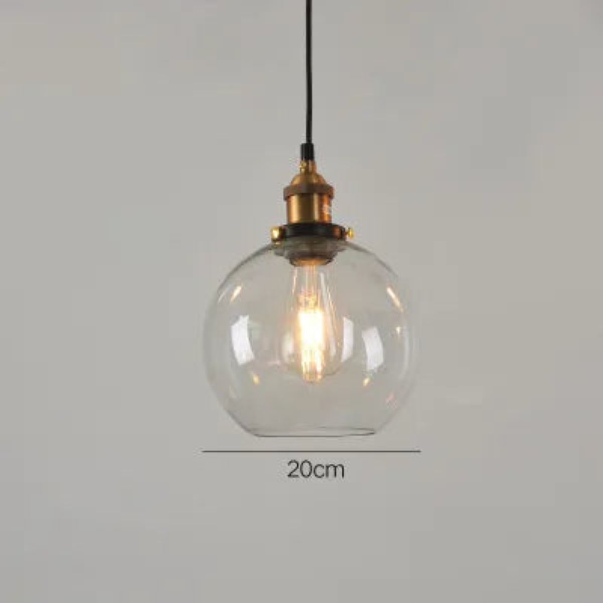 Single clear glass globe pendant light with antique brass socket and Edison filament bulb on black cord, 20cm diameter — LivDecor
