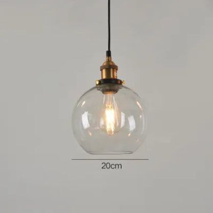Single clear glass globe pendant light with antique brass socket and Edison filament bulb on black cord, 20cm diameter — LivDecor
