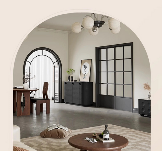Aura Glass Wabi-Sabi display cabinet in black styled against a glass partition wall in a warm neutral living room with arched doorway and globe chandelier — LivDecor
