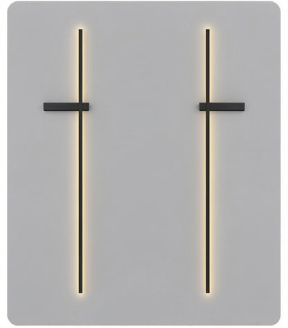 Pair of black minimalist linear LED wall sconces mounted as mirrored left and right versions, both emitting a warm glow on a grey background — LivDecor
