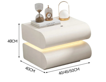 Aura Smart LED luxury nightstand in white cream tech leather with S-curve silhouette and warm LED base glow showing dimensions 40x40cm with 40/45/50cm width options on white background — LivDecor
