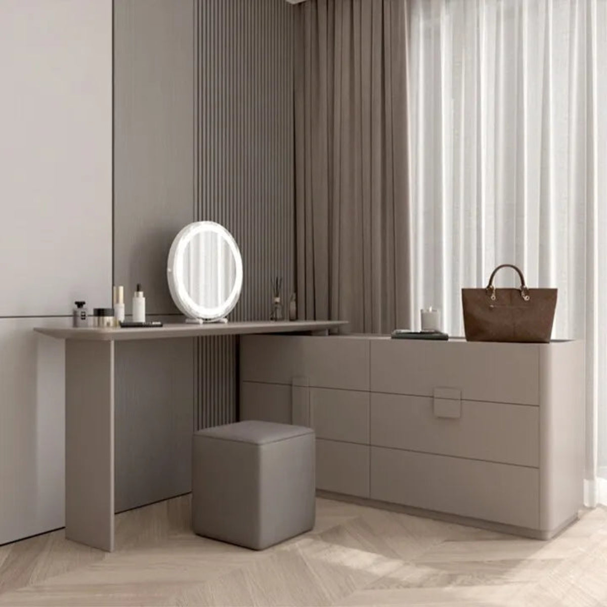Aura Suite luxury vanity dresser set in greige taupe with oval LED mirror, cube stool, and integrated vanity desk angled view with natural light through sheer curtains in a minimalist bedroom — LivDecor
