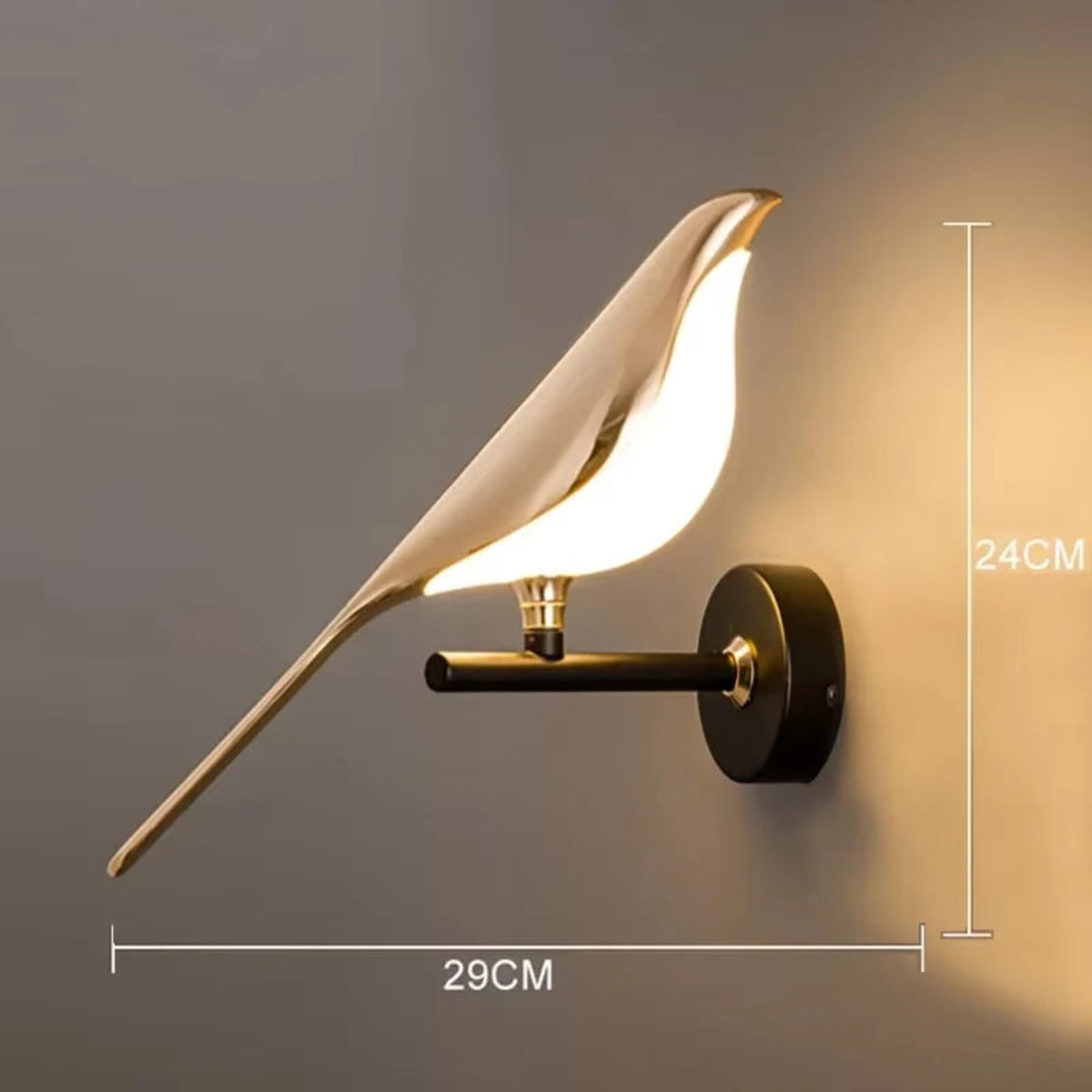 Avis Modern Origami Bird LED wall sconce in gold with matte black arm and round wall plate single-bird configuration illuminated showing dimensions 24cm height by 29cm width on a warm grey wall — LivDecor
