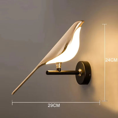 Avis Modern Origami Bird LED wall sconce in gold with matte black arm and round wall plate single-bird configuration illuminated showing dimensions 24cm height by 29cm width on a warm grey wall — LivDecor
