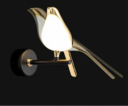 Avis Modern Origami Bird LED wall sconce in gold with glowing frosted white body and matte black arm single-bird configuration illuminated showing swivel arm range against a pure black background — LivDecor