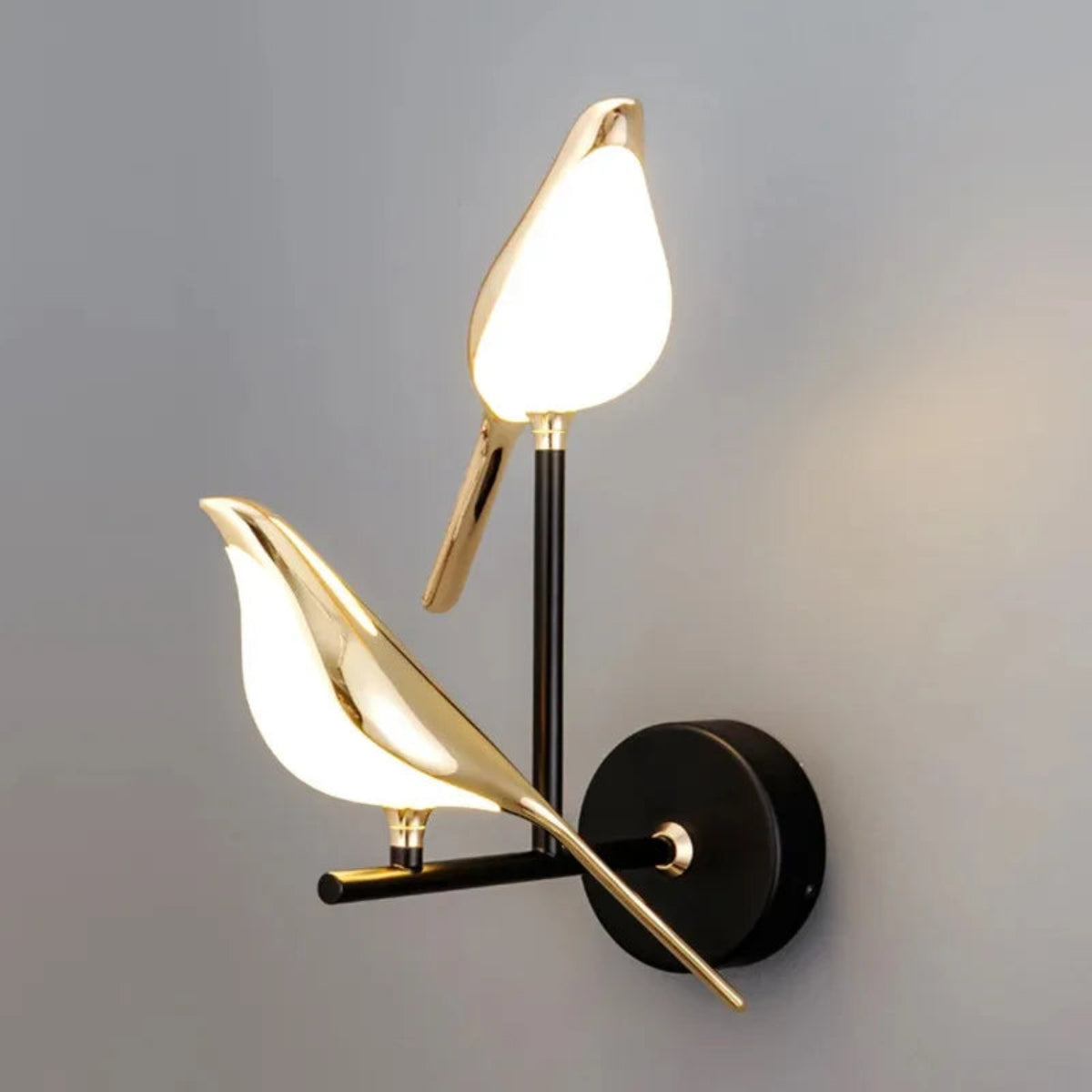 Avis Modern Origami Bird LED wall sconce in gold and matte black two-bird configuration both illuminated in diagonal composition showing full staggered arm silhouette on soft grey background — LivDecor
