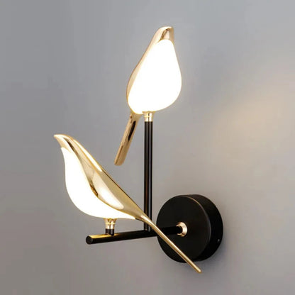 Avis Modern Origami Bird LED wall sconce in gold and matte black two-bird configuration both illuminated in diagonal composition showing full staggered arm silhouette on soft grey background — LivDecor
