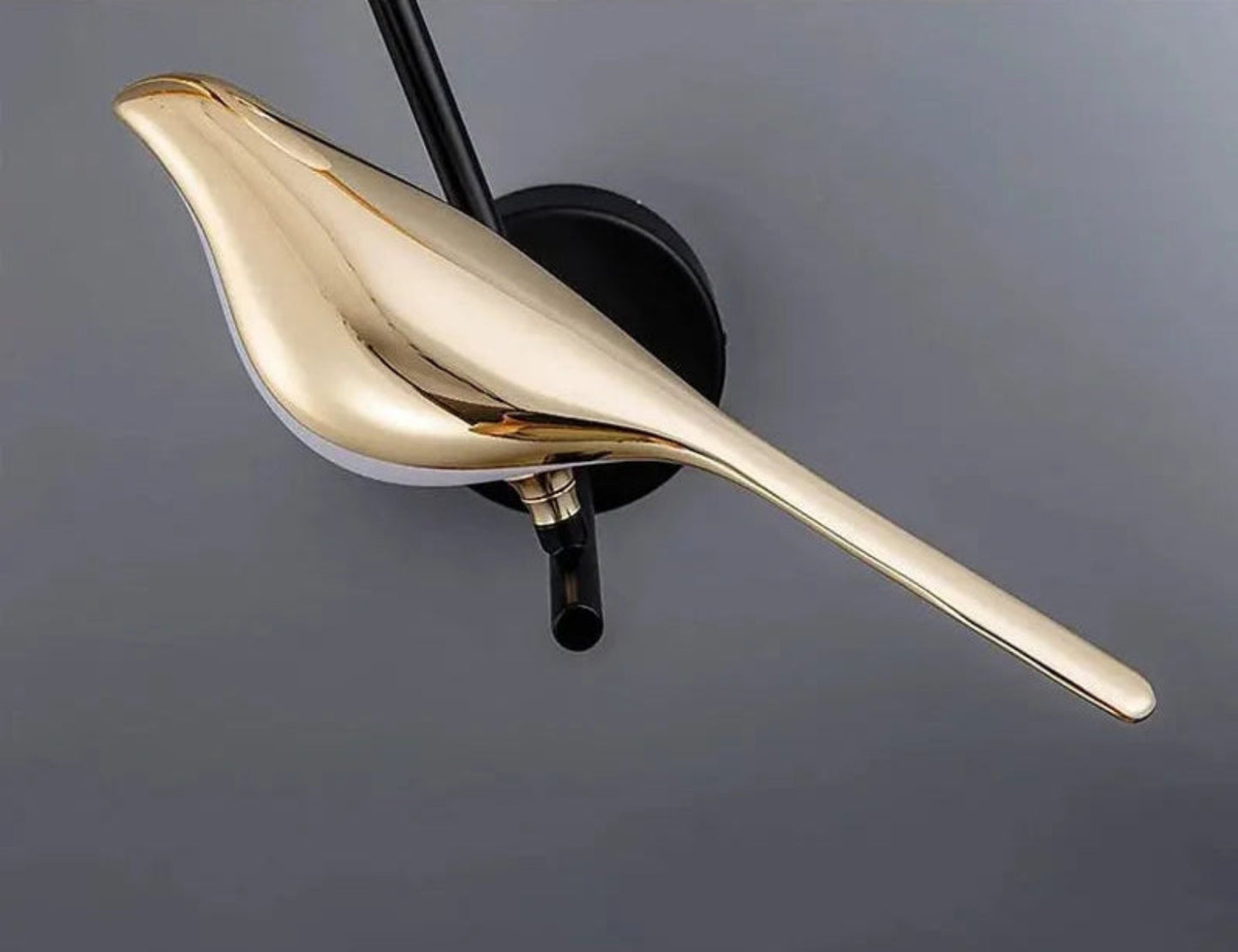 Avis Modern Origami Bird LED wall sconce close-up of mirror electroplated gold bird body and pivot joint against a warm grey wall — LivDecor
