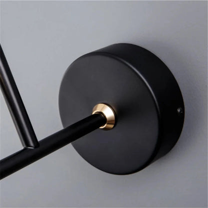 Avis Modern Origami Bird LED wall sconce macro close-up of matte black round wall plate with polished gold collar where the arm exits against a soft grey wall — LivDecor
