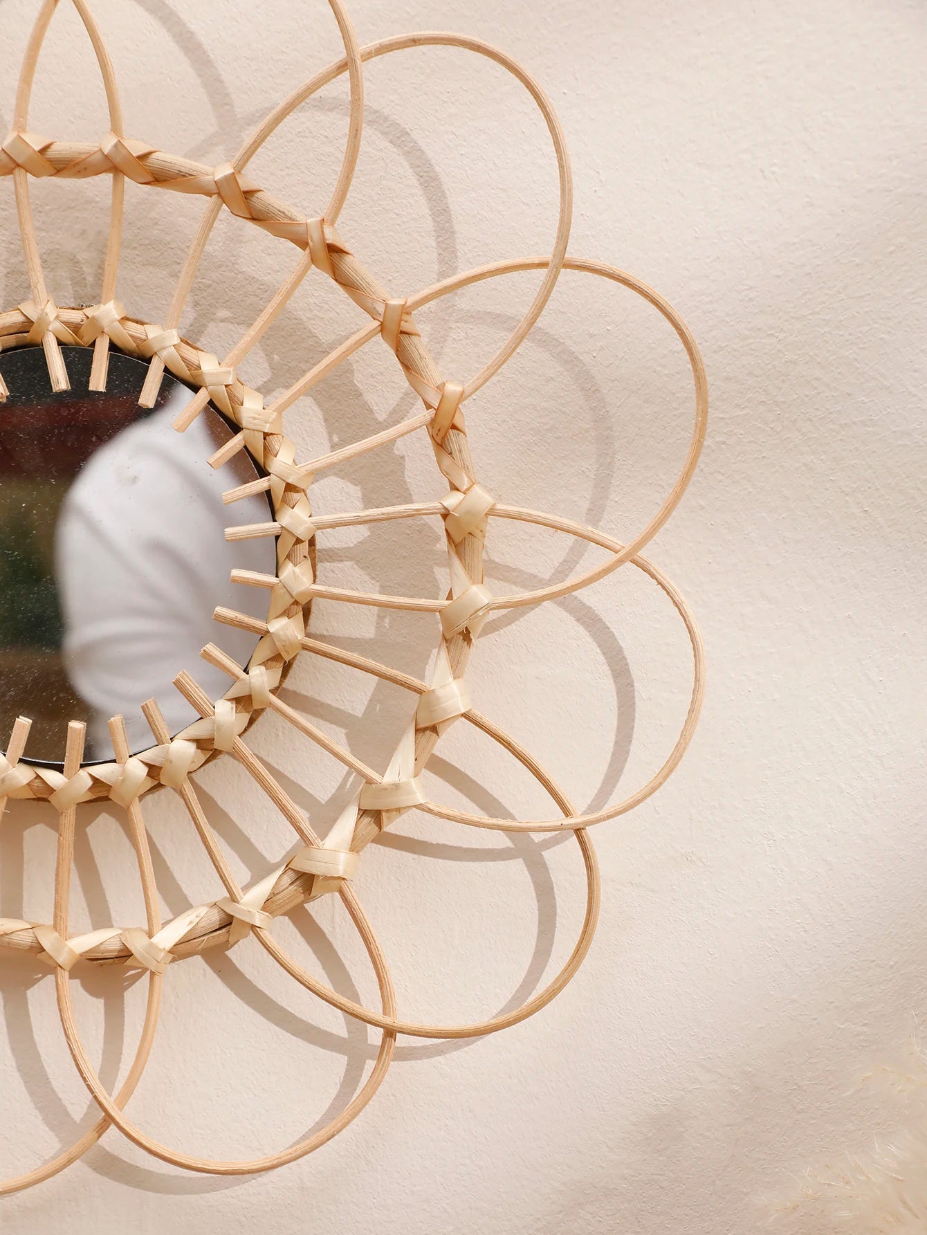 Close-up detail of boho rattan sunflower wall mirror showing hand-woven natural cane petal loops and woven center ring construction — LivDecor