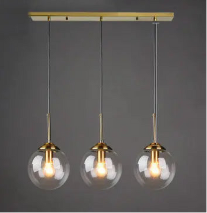 Three clear glass globe pendant lights on gold cord and linear ceiling mount displayed against a neutral grey background — LivDecor