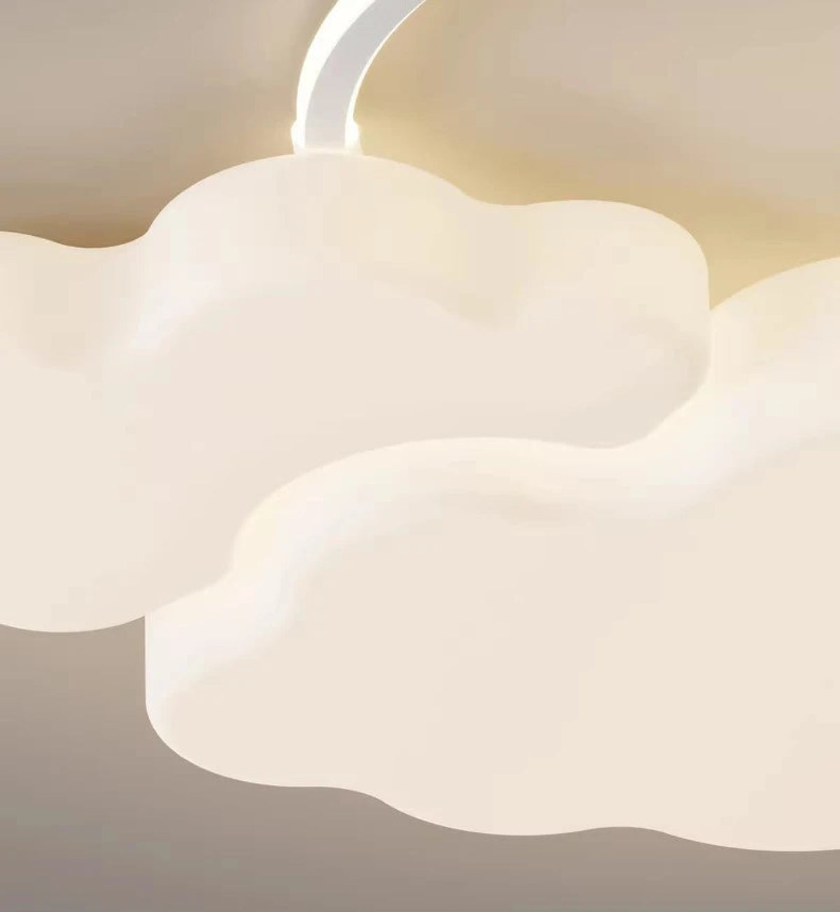 Close-up macro detail of the Cumulus Luxe cream sculptural cloud LED ceiling light showing soft cloud body texture and warm glowing halo ring on a warm white ceiling — LivDecor
