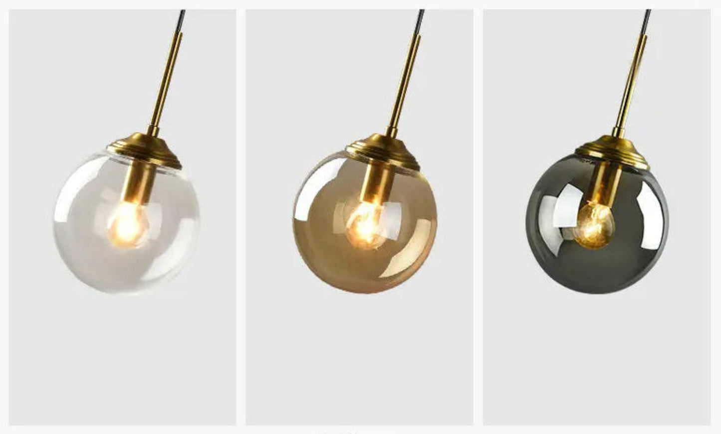 Three glass globe pendant lights side by side showing clear, amber, and smoke grey colorway options with gold hardware and warm filament bulbs against a light grey background — LivDecor
