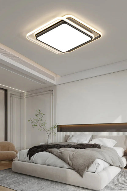 Halo modern tricolor LED flush mount ceiling light in matte black square frame glowing warm white in a classical-modern bedroom with ornate wall paneling, branchy plant, and cream lounge chair — LivDecor
