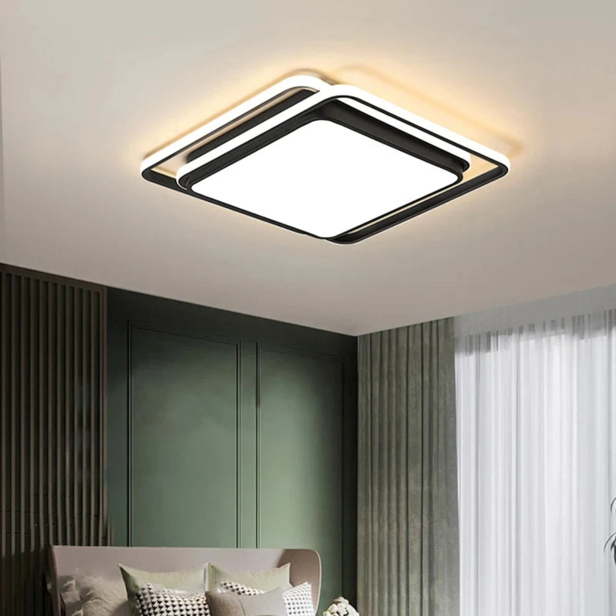 Halo modern tricolor LED flush mount ceiling light in matte black square frame glowing warm white in a moody bedroom with dark green wall panels, linen bedding, and sheer curtains — LivDecor
