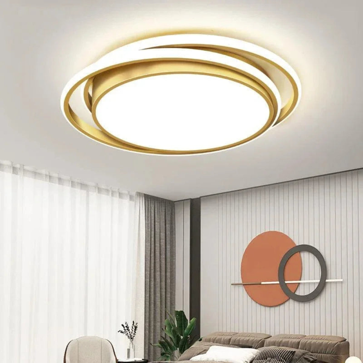 Halo modern tricolor LED flush mount ceiling light in golden round double-ring frame glowing warm white in a bright modern living room with sheer curtains, circular wall art, and sofa — LivDecor

