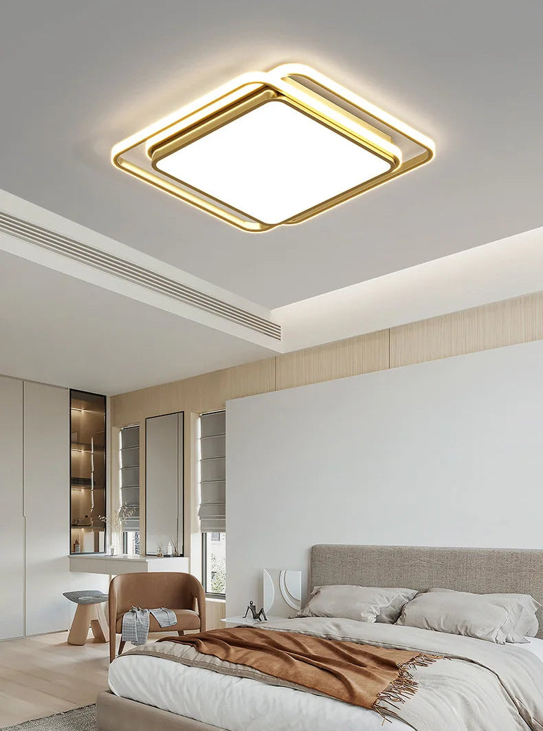 Halo modern tricolor LED flush mount ceiling light in golden square frame glowing warm white installed in a Japandi-style bedroom with linen bedding, neutral tones, and natural window light — LivDecor
