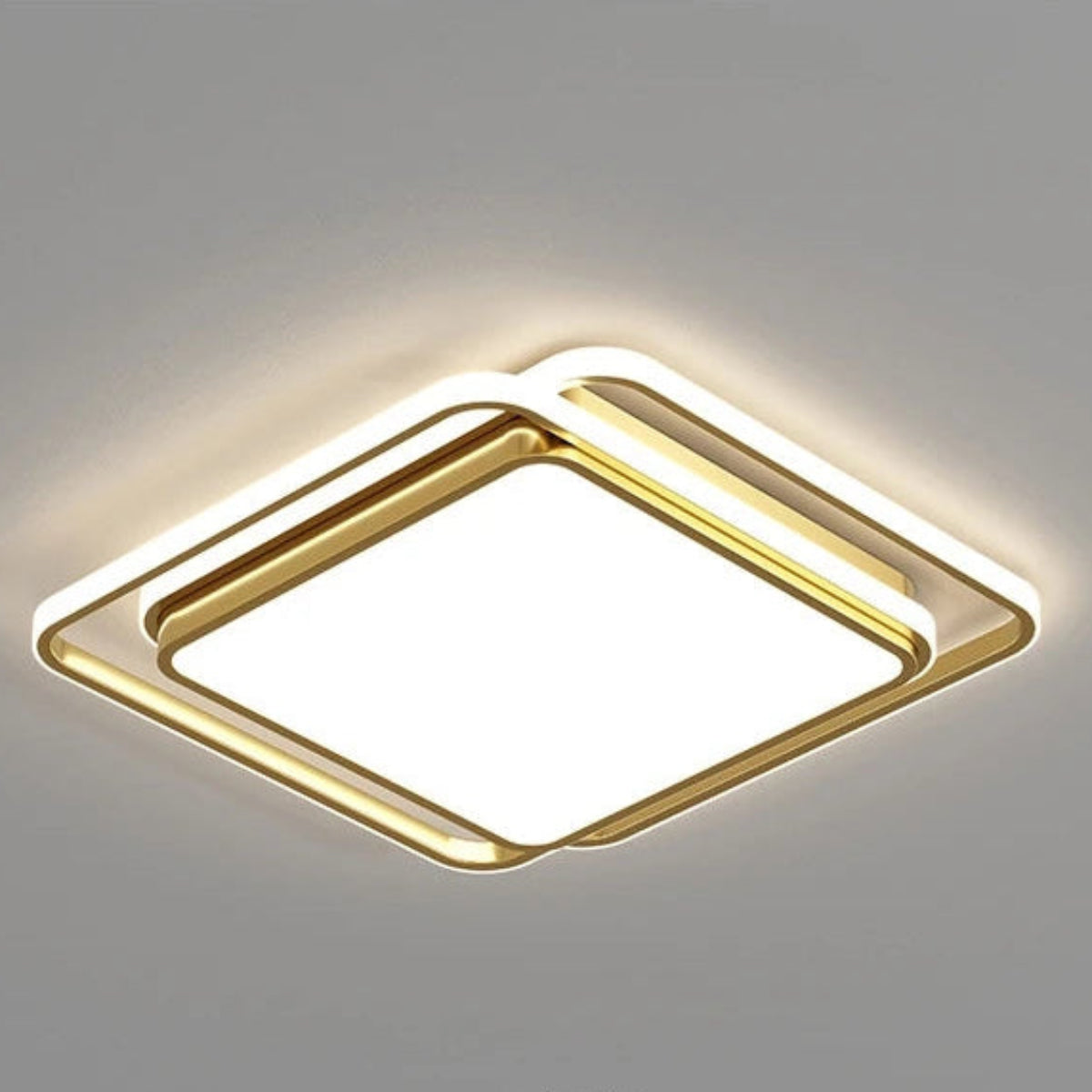 Halo modern tricolor LED flush mount ceiling light in golden square frame switched on showing warm amber halo glow on a grey ceiling — LivDecor
