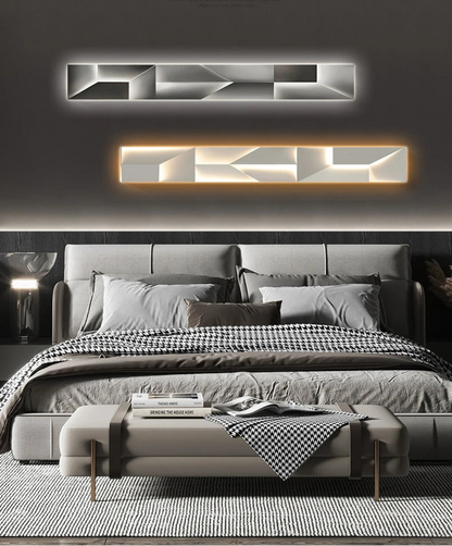 Luminary Canvas backlit crystal art wall sconce in horizontal configuration shown in cool white and warm LED tones above a styled grey bed with bench and houndstooth throw in a modern bedroom — LivDecor
