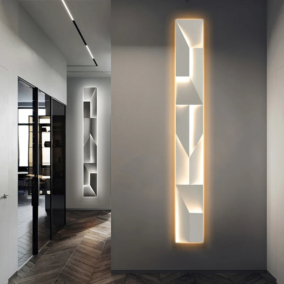 Luminary Canvas backlit crystal art wall sconce in vertical configuration with warm LED glow mounted in a sleek modern hallway with herringbone wood floors and glass partition — LivDecor