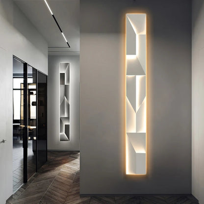 Luminary Canvas backlit crystal art wall sconce in vertical configuration with warm LED glow mounted in a sleek modern hallway with herringbone wood floors and glass partition — LivDecor