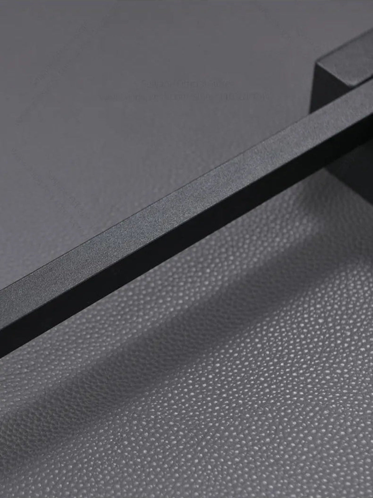 Close-up detail of minimalist linear LED wall sconce matte black textured finish and slim profile against a grey background — LivDecor
