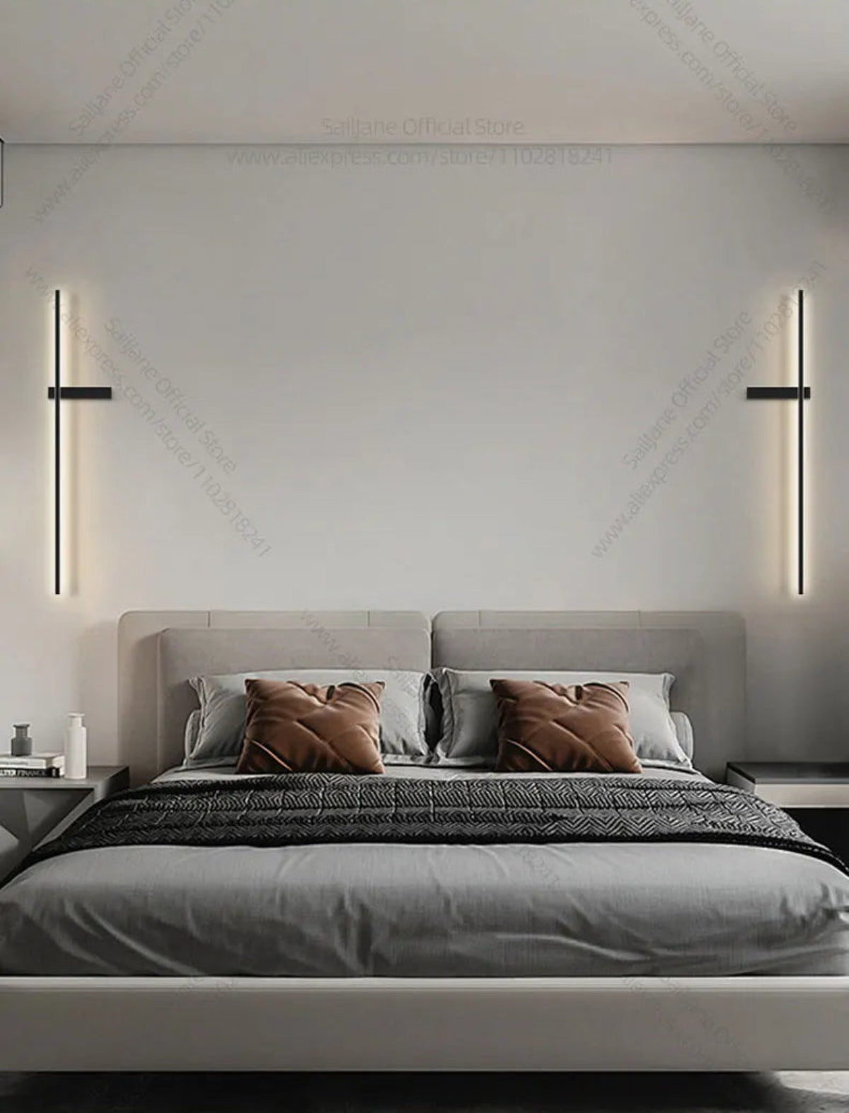 Pair of minimalist linear LED wall sconces in matte black mounted symmetrically on either side of a grey upholstered bed in a modern bedroom lifestyle shot — LivDecor
