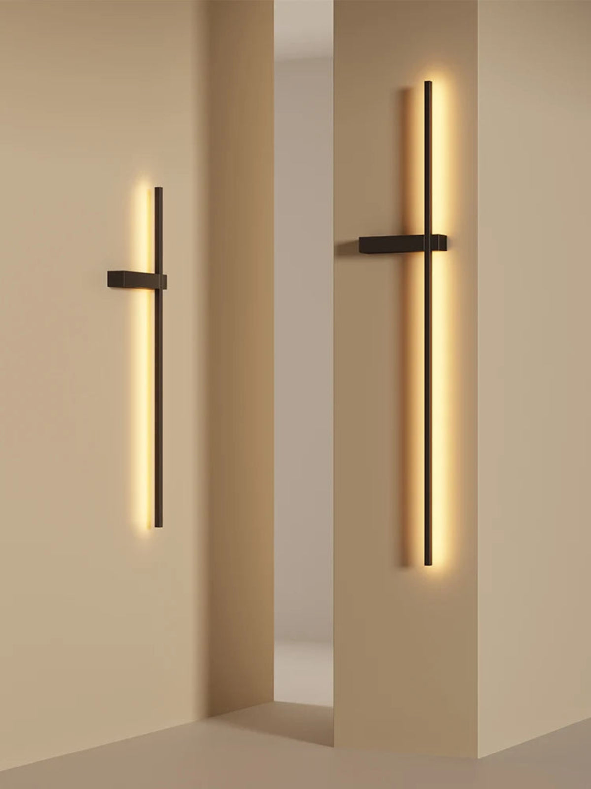 Pair of minimalist linear LED wall sconces in matte black mounted on warm sand-toned architectural columns casting rich amber glow in a modern interior lifestyle shot — LivDecor
