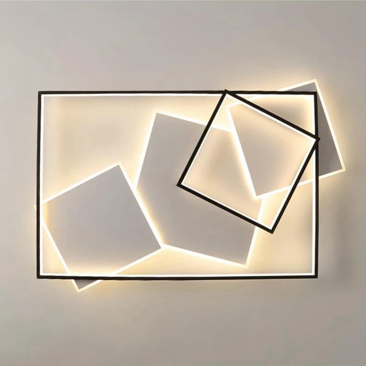 Modern geometric LED flush mount ceiling light with black rectangle frame and angled floating square panels glowing warm white on a neutral background — LivDecor
