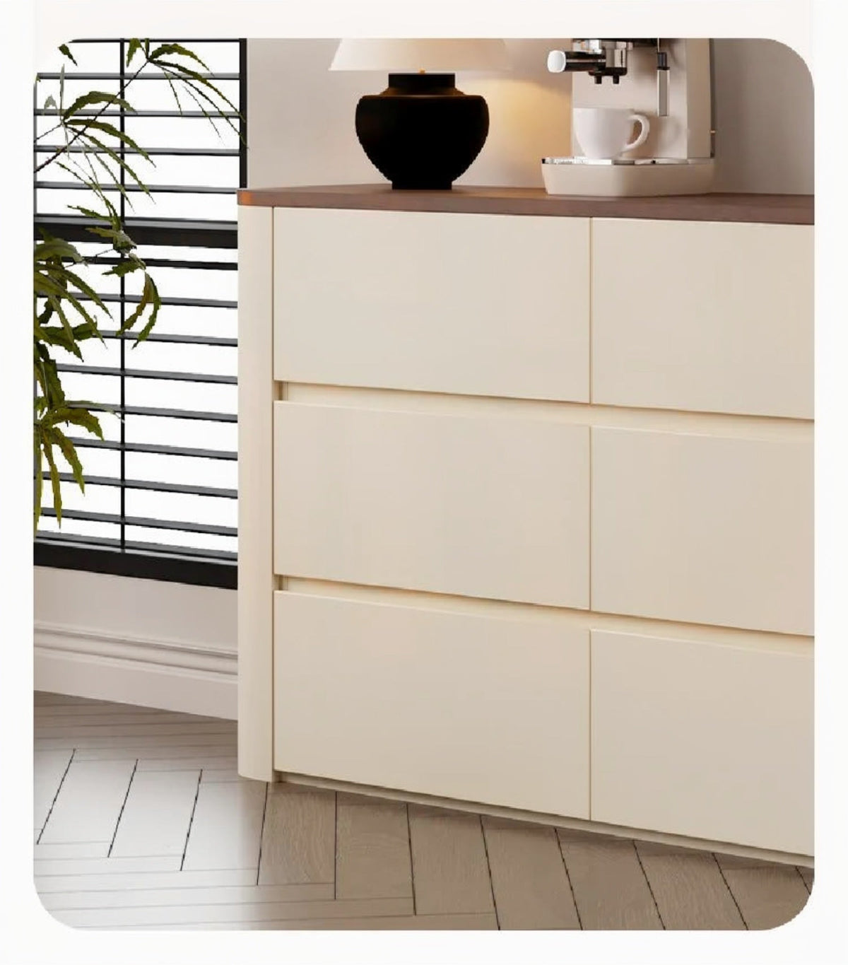Nordic Elegance credenza detail showing cream handleless grooved drawer fronts, walnut top edge and rounded corner beside a window with a plant — LivDecor
