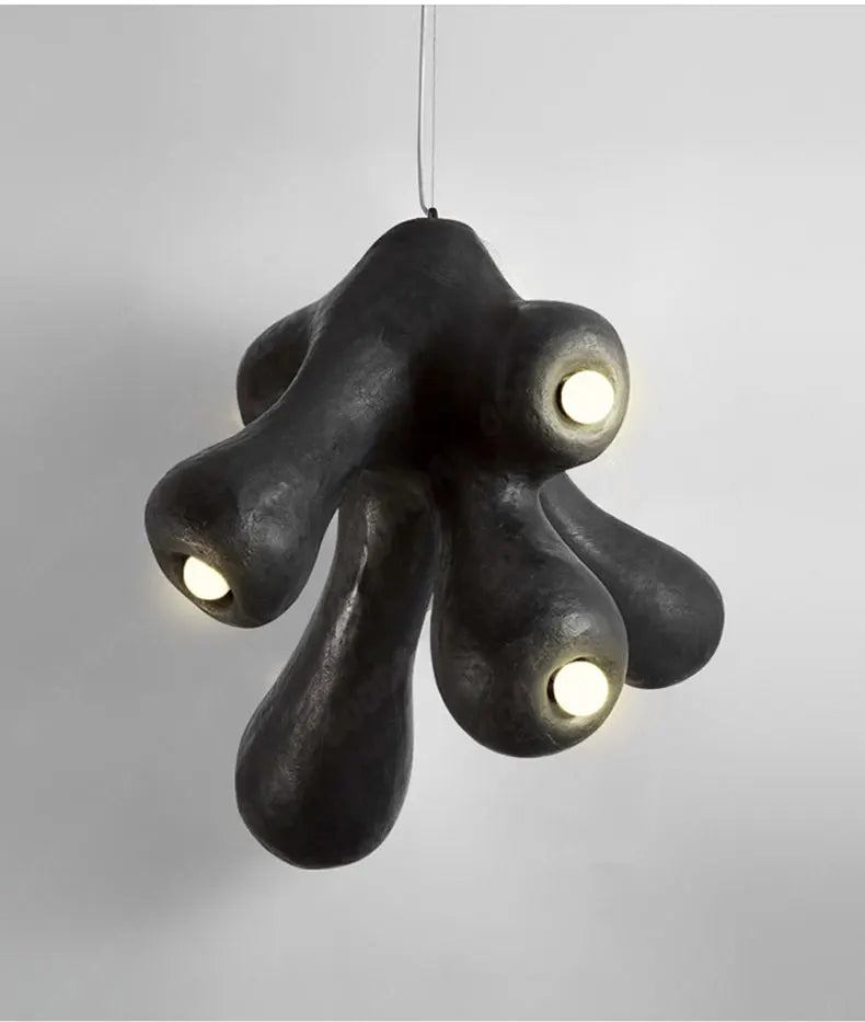 Odense Cocoon sculptural cloud pendant chandelier in black with 4-head organic cluster fully lit with warm glow on a neutral grey background — LivDecor

