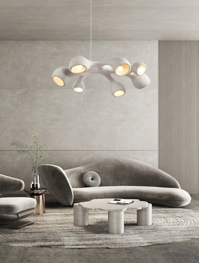 Odense Cocoon sculptural cloud pendant chandelier in white 3-head linear configuration hanging in a Mediterranean arch living room with tropical greenery, round wood coffee table, and bouclé chairs — LivDecor
