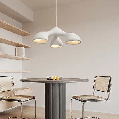 Odense Cocoon sculptural cloud pendant chandelier in white 3-head downward configuration hanging over a fluted dark round dining table with cane Cesca chairs and open wood shelving — LivDecor

