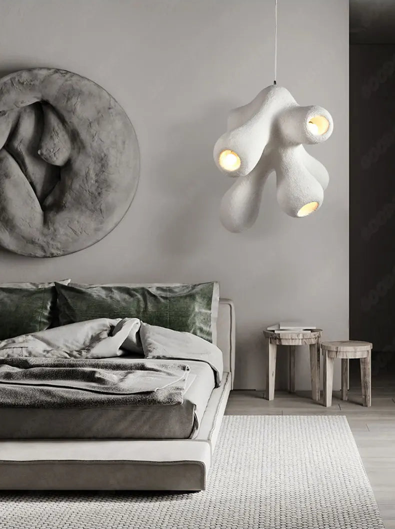 Odense Cocoon sculptural cloud pendant chandelier in white with 4-head organic cluster glowing in a moody grey bedroom styled with sculptural wall art, green velvet pillows, and raw wood stools — LivDecor
