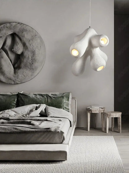 Odense Cocoon sculptural cloud pendant chandelier in white with 4-head organic cluster glowing in a moody grey bedroom styled with sculptural wall art, green velvet pillows, and raw wood stools — LivDecor
