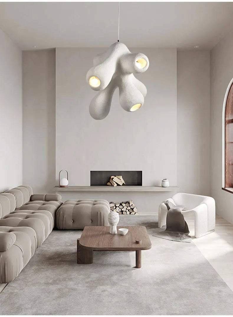 Odense Cocoon sculptural cloud pendant chandelier in white with 4-head organic cluster hanging in a minimalist neutral living room with tufted modular sofa, wood coffee table, and fireplace — LivDecor
